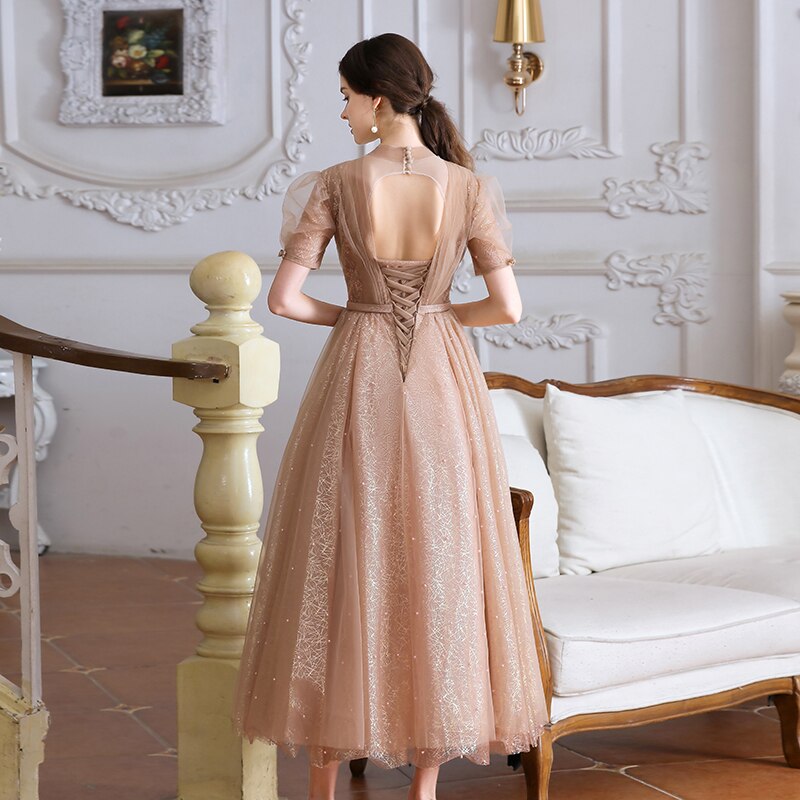 This stunning tea length dress, the Robe Tiffany, will make you feel like royalty. With its sparkling design, it exudes a princess-like elegance that is sure to turn heads. Perfect for any formal event, this dress is both stylish and sophisticated. Channel your inner princess with the Robe Tiffany.