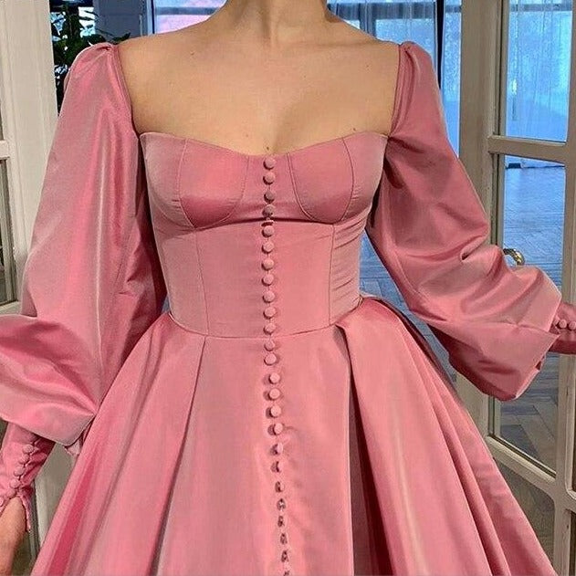 Evoke fairy tale fantasies in our Robe Eloise. The rose pink taffeta gown creates a flattering A-line silhouette with a structured bodice and lace-up back, while the gathered skirt and train exude elegance and sophistication. Complete the enchanting look with our specially designed embroidered ruffle heart gloves. Perfect for balls, weddings, and grand occasions.