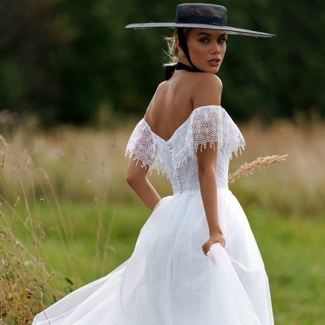 "Unleash your inner boho beauty with our Robe Franchele! This stunning A-line wedding dress features a sweetheart neckline, open back, and delicate embroidery lace. Complete with fringe arm bands for a touch of whimsy. Let your free-spirited style shine on your special day!"