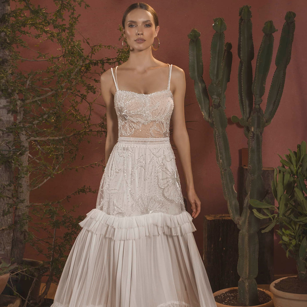 Step into elegance with the Robe Darianne, a stunning white bridal gown for the bohemian bride. Featuring delicate spaghetti straps and a vintage-inspired design, this gown will make you feel like a true goddess on your special day. Embrace your free spirit and walk down the aisle in style!