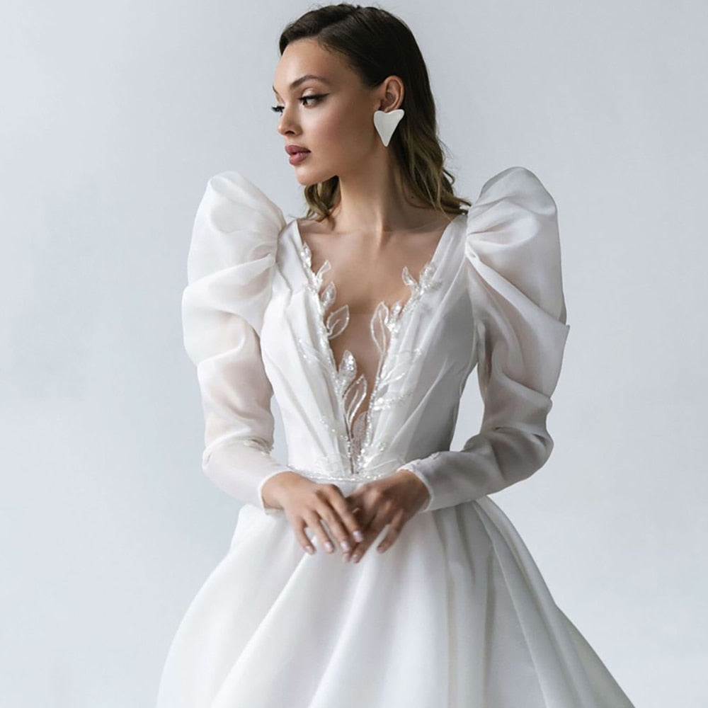 Introducing the exquisite Robe Harleigh, a showstopper among bridal gowns. Its elegant design boasts long sleeves, a chic V-neck, and exquisite embroidery. Embody sophistication and grace on your special day with this luxurious robe.