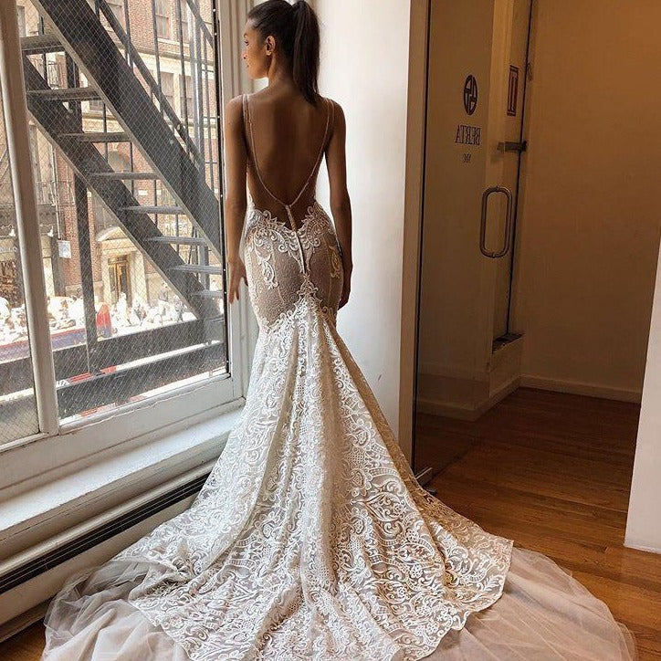 Upgrade your wardrobe with the daring Robe Meja. This mermaid style wedding dress features an alluring open back, delicate lace, and thin straps for a sexy beach-ready look. Perfect for plus size brides who love to take risks and make a statement on their big day!