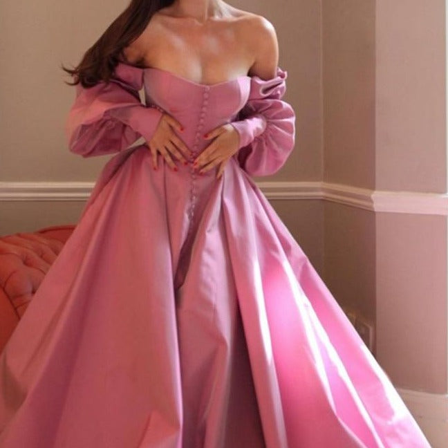 Evoke fairy tale fantasies in our Robe Eloise. The rose pink taffeta gown creates a flattering A-line silhouette with a structured bodice and lace-up back, while the gathered skirt and train exude elegance and sophistication. Complete the enchanting look with our specially designed embroidered ruffle heart gloves. Perfect for balls, weddings, and grand occasions.