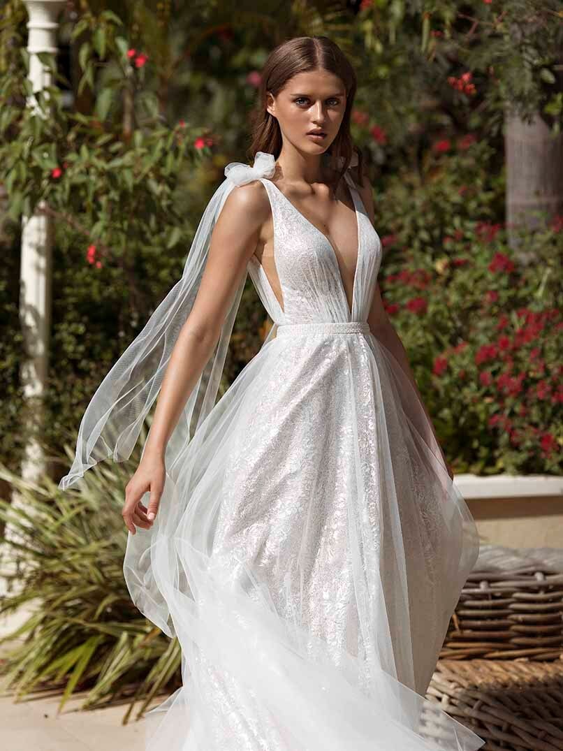 "Get ready to shine on your special day with the Robe Mariette. This beautiful white sparkling dress features v-neckline for a dreamy bridal look. Designed to make you feel confident and radiant, it's the perfect gown for your wedding."