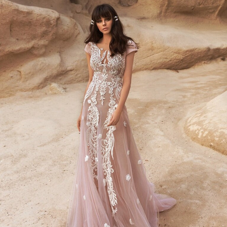 Exude elegance and charm on your special day with the Robe Amira wedding dress. The chic and dusty pink design adds a touch of bridal glamour, making you shine on your wedding day. Walk down the aisle in style and make a lasting impression with this beautiful and timeless gown.