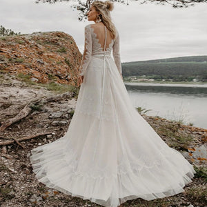 Introducing the Robe Elize, a sophisticated and elegant bridal dress perfect for your beach bohemian wedding. Featuring beautiful lace applique, a transparent long sleeve design, and a chic V-neckline, this plus size dress will make you feel like a ethereal goddess on your special day.