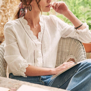 Introducing the Blouse Leonise, a classic vintage top for women. Made with a beautiful white lace graphic print, this blouse features a V-neck and long sleeves for a timeless and casual look. Elevate your wardrobe with this versatile and elegant piece.