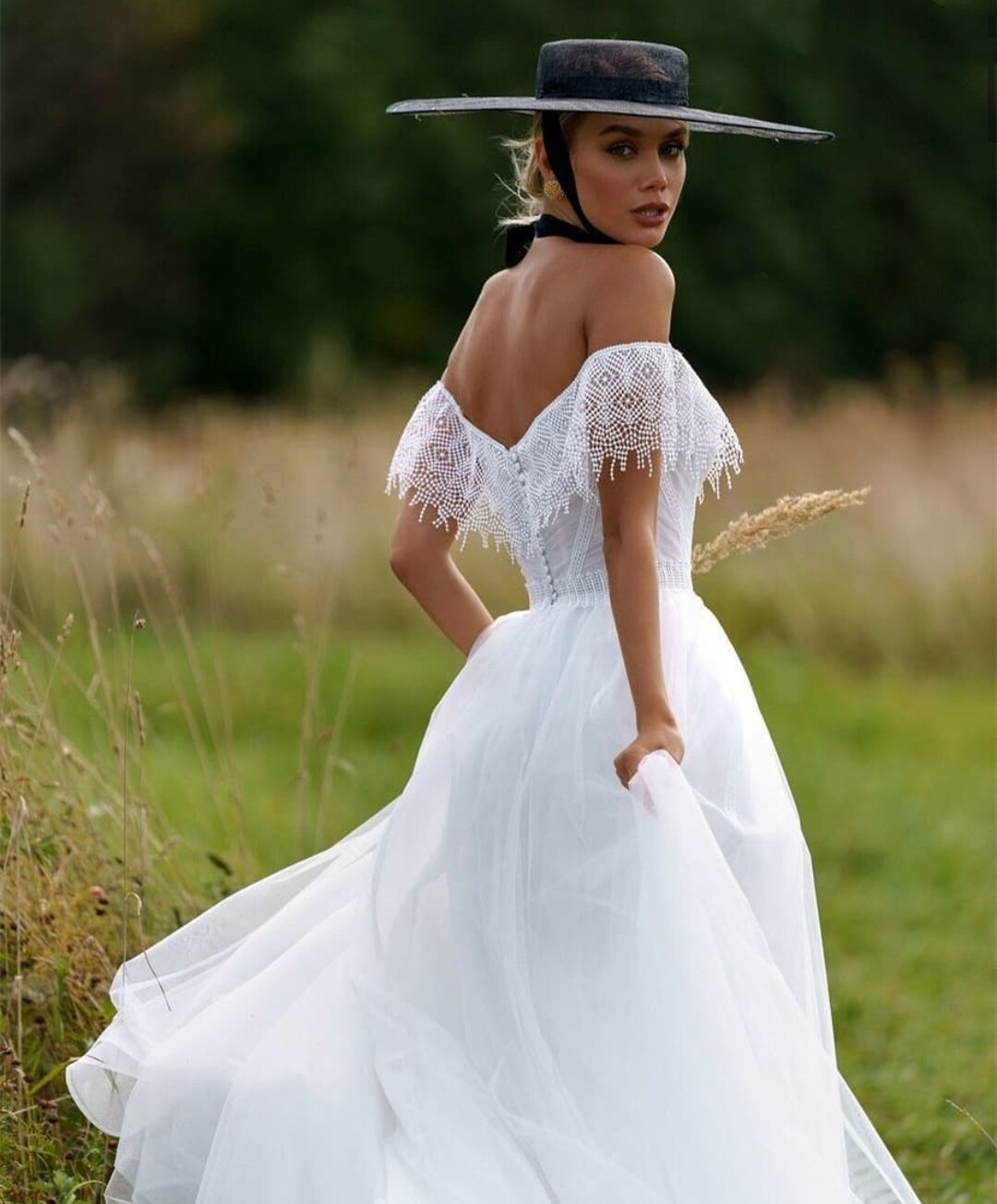 "Unleash your inner boho beauty with our Robe Franchele! This stunning A-line wedding dress features a sweetheart neckline, open back, and delicate embroidery lace. Complete with fringe arm bands for a touch of whimsy. Let your free-spirited style shine on your special day!"