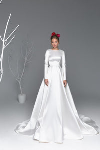 This white satin A-line gown, named Robe Asenat, is the perfect blend of elegant and modern design. The fluid motion of the A-line silhouette accentuates your natural curves, while the luxurious satin fabric provides a subtle sheen. Make a statement at your next special event with this timeless gown.