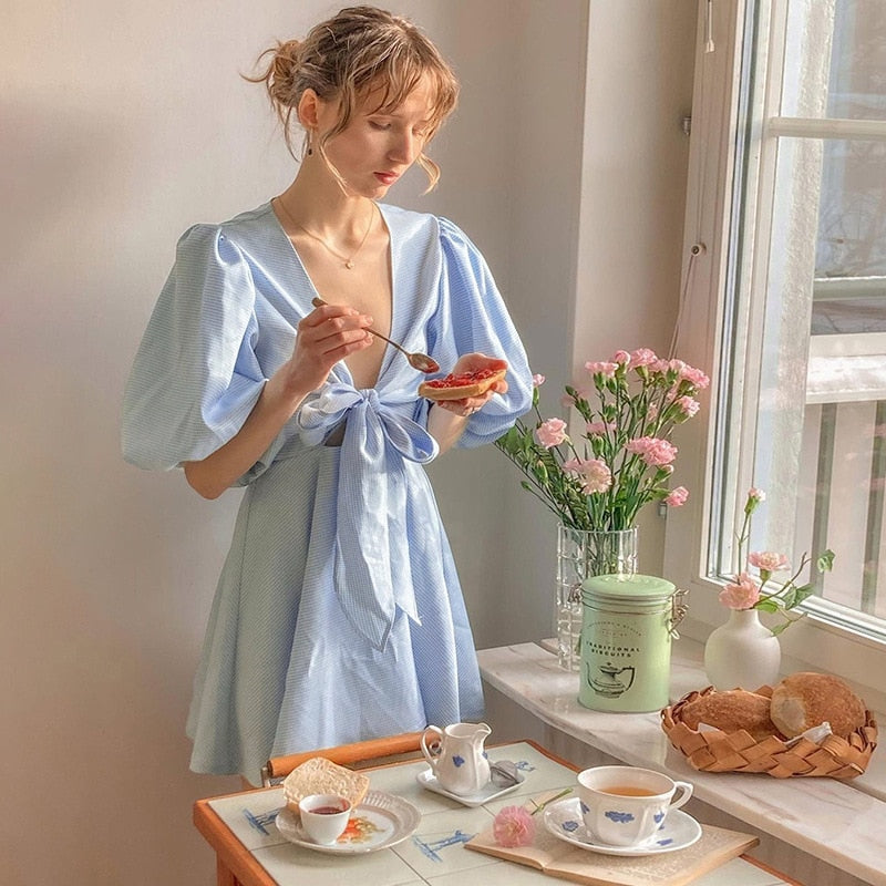 Introducing the elegant and versatile Robe Agnes. Crafted with light blue lace and a deep V-neck, this summer dress is perfect for parties and vacations. The puffed sleeves add a touch of sophistication to this checkered mini dress. Elevate your summer wardrobe with this must-have piece.