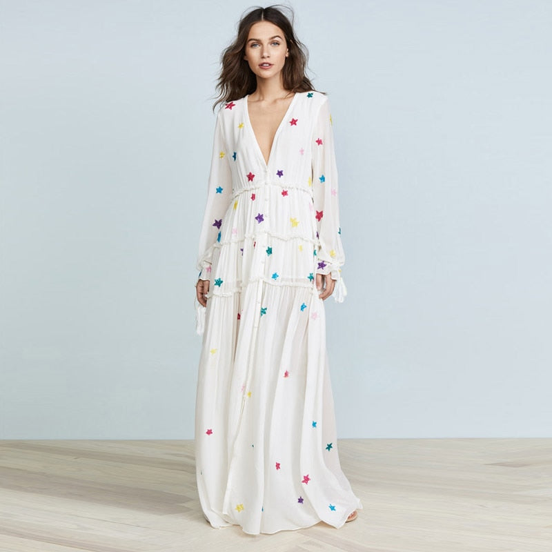 Introducing the Robe Antoinette - the perfect addition to your wardrobe. Featuring a loose and flowy fit, embroidered star accents, deep v-neckline, and long sleeves, this maxi dress is perfect for an effortless bohemian look. Ideal for vacations and beach days.