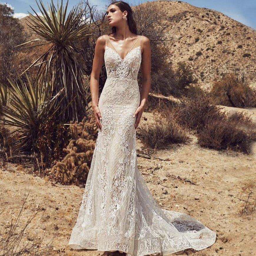 "Make a statement with our Robe Dominique, a chic white gown crafted with satin and lace. Perfect for a desert sun bridal look, this mermaid-style robe adds a touch of elegance to your special day. Get ready to shine, bride! 