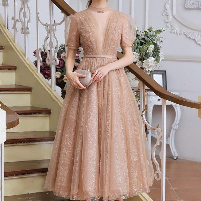 This stunning tea length dress, the Robe Tiffany, will make you feel like royalty. With its sparkling design, it exudes a princess-like elegance that is sure to turn heads. Perfect for any formal event, this dress is both stylish and sophisticated. Channel your inner princess with the Robe Tiffany.