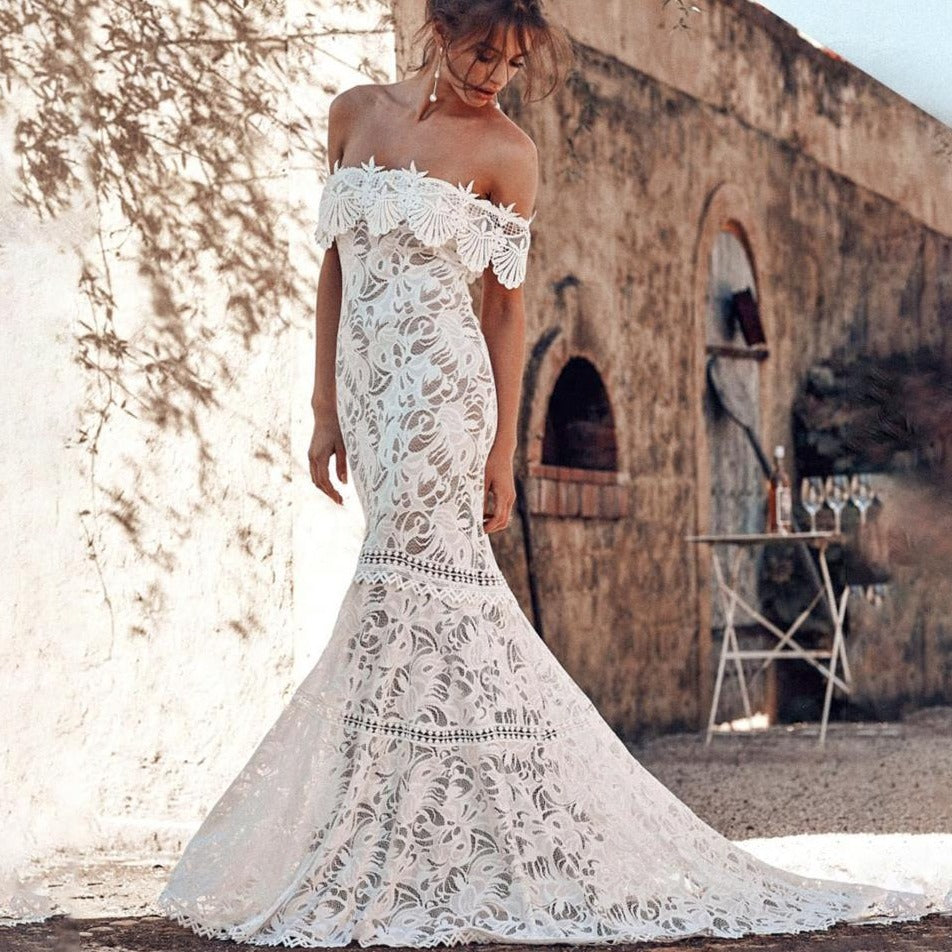 Discover elegance and charm with our Robe Soleine, the perfect choice for any wedding. This boho mermaid gown features intricate embroidery and a chic off shoulder design that will make you feel like a beautiful bride. With its unique style and flattering silhouette, you'll turn heads on your special day.