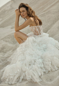 This elegant ruffle wedding gown, Robe Agne, exudes sophisticated charm and timeless beauty. The delicate ruffles add a touch of romance while flattering the figure. Made for the modern bride, this gown is a perfect blend of style and grace.