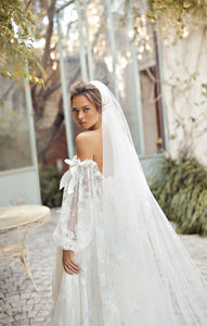 Indulge in luxury with our Robe Auburne, an elegant wedding gown featuring delicate embroidered lace and a chic long veil. This dress will make you feel like a work of art as you walk down the aisle, exuding sophistication and exclusivity. Elevate your special day with an exquisite touch of fashion.