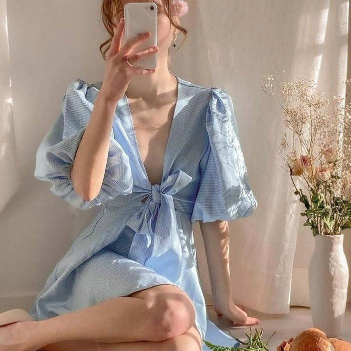 Introducing the elegant and versatile Robe Agnes. Crafted with light blue lace and a deep V-neck, this summer dress is perfect for parties and vacations. The puffed sleeves add a touch of sophistication to this checkered mini dress. Elevate your summer wardrobe with this must-have piece.