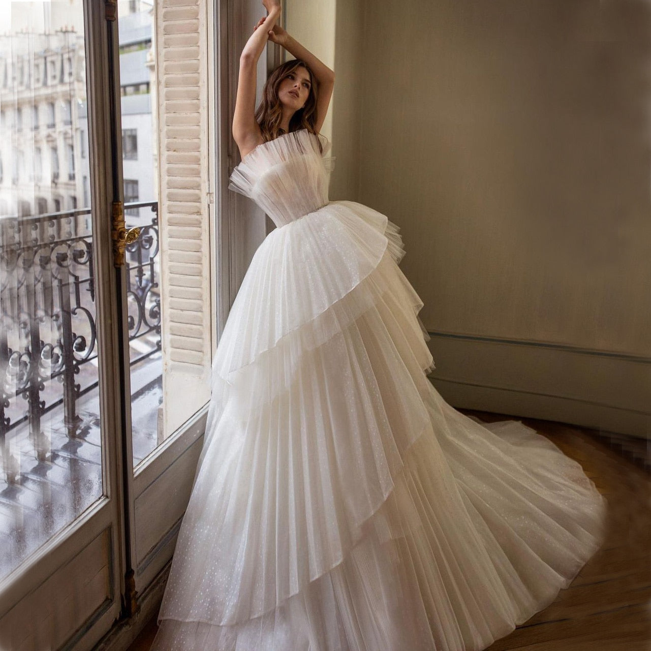 Indulge in pure luxury with the Robe Maneta. Crafted from delicate tulle and featuring cascading ruffles, this off-the-shoulder wedding gown is the epitome of sophistication. Its floor-length design adds an air of elegance, making it the perfect choice for your special day.