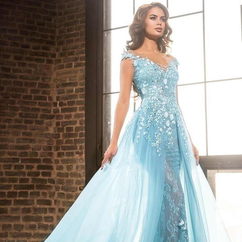 Expertly crafted with intricate blue illusion lace and beaded appliques, the Robe Marigold is a stunning prom dress for a luxurious evening. The flowing court train adds an elegant touch while showcasing your figure. Make a statement in this long, glamorous gown.