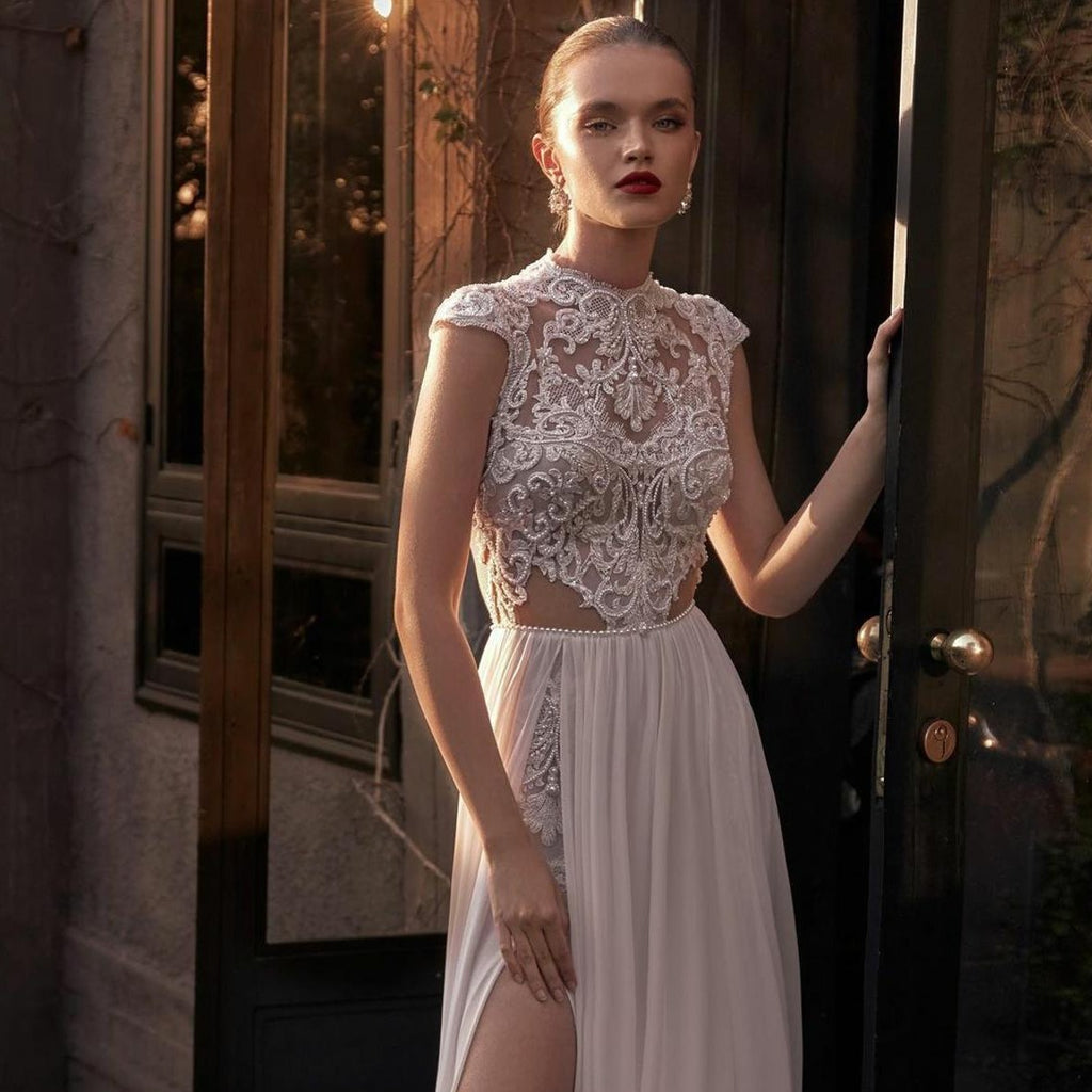 Enhance your special day with the luxurious Robe Lian. This exquisite Wedding Dress features a jewel neckline, delicate lace appliques, and elegant cap sleeves, all crafted with the finest chiffon fabric. The sweeping train and custom fit make this Boho-inspired dress a must-have for the sophisticated bride.