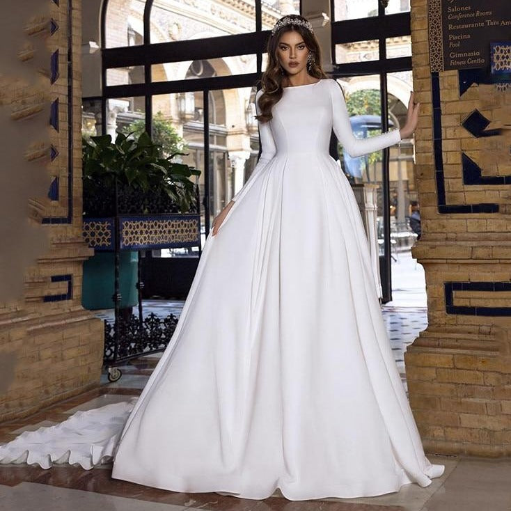 Look and feel like a princess in the sophisticated Robe Eathelin. This white bridal wedding gown features long sleeves and a flattering fit. Show off your true beauty and timeless elegance on your special day.