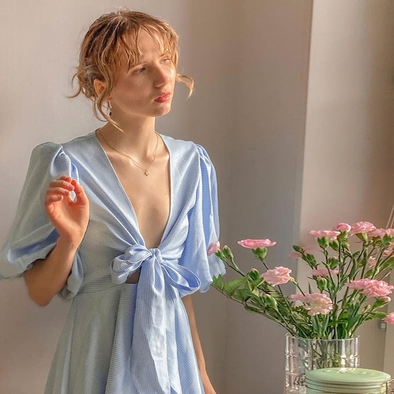 Introducing the elegant and versatile Robe Agnes. Crafted with light blue lace and a deep V-neck, this summer dress is perfect for parties and vacations. The puffed sleeves add a touch of sophistication to this checkered mini dress. Elevate your summer wardrobe with this must-have piece.