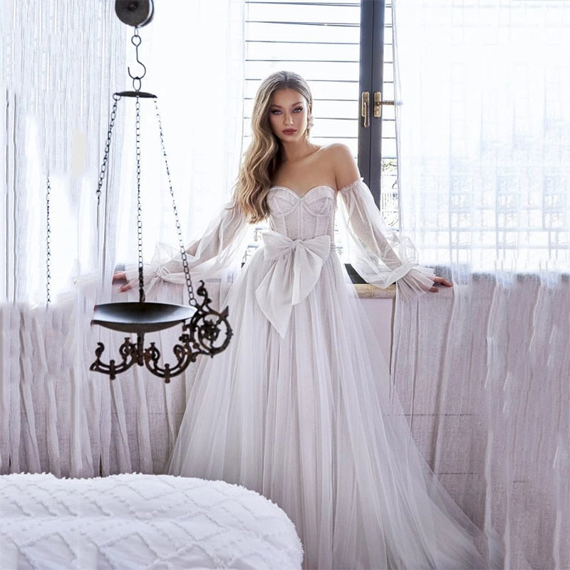 Let yourself feel like a celestial goddess in the exquisite Robe Rennie. Featuring gorgeous out of this world ball sleeves, this wedding gown will give you an elegant and other-worldly look that will make your special day even more spectacular. Dare to make a statement and amaze your guests!