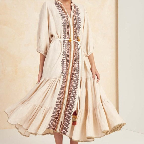 The Robe Etta is a stunning statement piece for any boho fashion enthusiast. With intricate embroidery, a lace-up detail, and charming tassel accents, this dress is both chic and eye-catching. The midi length and lantern sleeves add a touch of elegance, making the Robe Etta the perfect addition to your wardrobe.