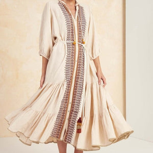 The Robe Etta is a stunning statement piece for any boho fashion enthusiast. With intricate embroidery, a lace-up detail, and charming tassel accents, this dress is both chic and eye-catching. The midi length and lantern sleeves add a touch of elegance, making the Robe Etta the perfect addition to your wardrobe.