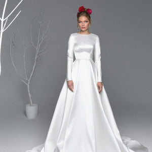 This white satin A-line gown, named Robe Asenat, is the perfect blend of elegant and modern design. The fluid motion of the A-line silhouette accentuates your natural curves, while the luxurious satin fabric provides a subtle sheen. Make a statement at your next special event with this timeless gown.