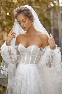 Indulge in luxury with our Robe Auburne, an elegant wedding gown featuring delicate embroidered lace and a chic long veil. This dress will make you feel like a work of art as you walk down the aisle, exuding sophistication and exclusivity. Elevate your special day with an exquisite touch of fashion.