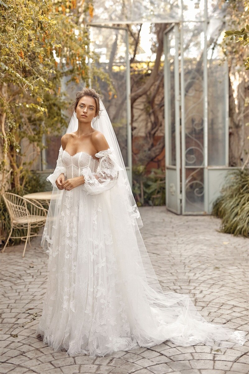 Indulge in luxury with our Robe Auburne, an elegant wedding gown featuring delicate embroidered lace and a chic long veil. This dress will make you feel like a work of art as you walk down the aisle, exuding sophistication and exclusivity. Elevate your special day with an exquisite touch of fashion.