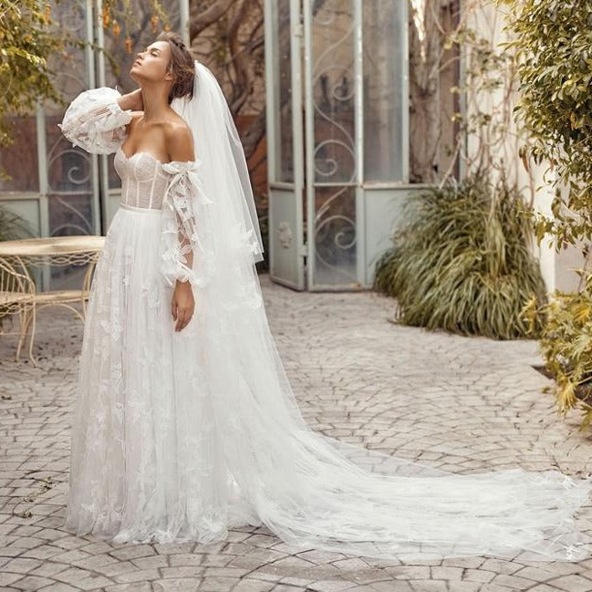 Indulge in luxury with our Robe Auburne, an elegant wedding gown featuring delicate embroidered lace and a chic long veil. This dress will make you feel like a work of art as you walk down the aisle, exuding sophistication and exclusivity. Elevate your special day with an exquisite touch of fashion.