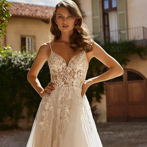 Discover timeless elegance with our Robe Libi wedding dress. Featuring delicate spaghetti straps and a flattering V-neckline, this exquisite dress is the perfect choice for the modern bride. With exquisite craftsmanship, this dress is designed to flatter and inspire. Feel beautiful on your special day!