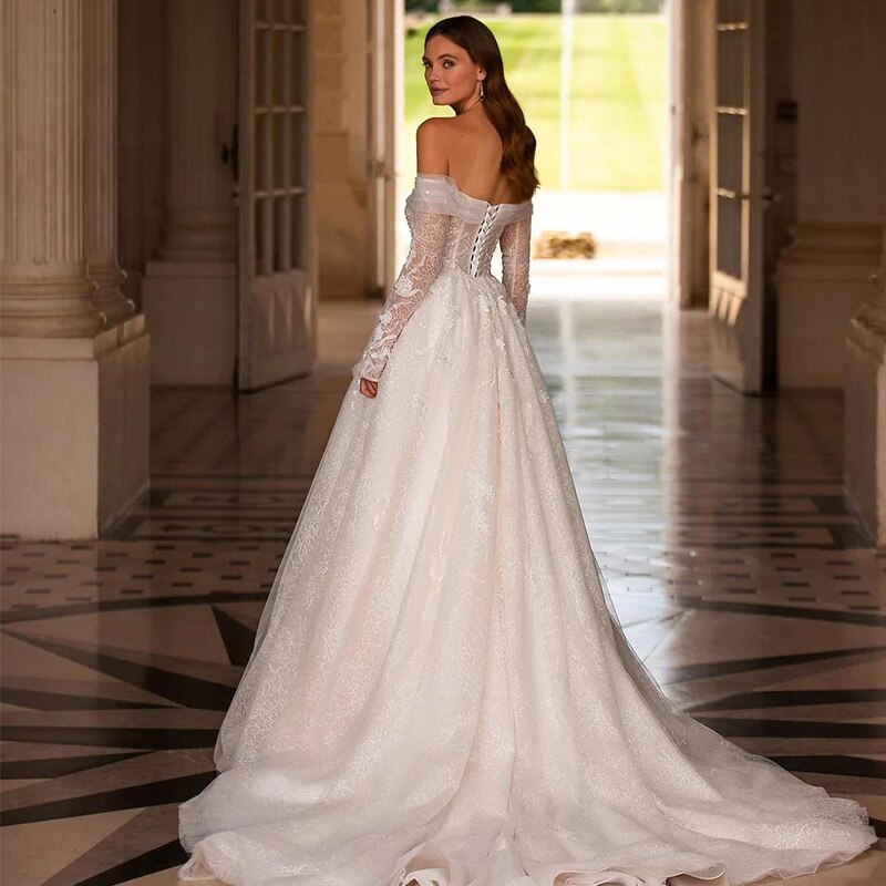 The Robe Effy is a stunning wedding dress with a unique trapeze design and elegant off-the-shoulder detail. The corset back adds a touch of glamour while ensuring a perfect fit. Perfect for any bride looking for a modern, yet timeless look on her special day.