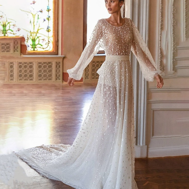 Introducing the elegant Robe Saffron, a custom floor-length A-line bridal gown with long sleeves and a round neckline. Designed for a perfect fit and a sophisticated look, this stunning robe is the perfect choice for any bride. Make a statement and feel confident on your special day with Robe Saffron.