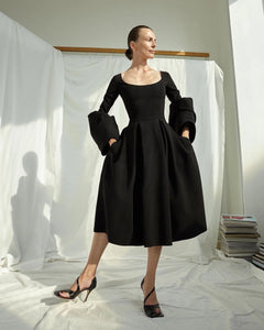 Architectural shapes and inherent femininity are two hallmarks of the A.W.A.K.E. Mode brand. Producing pieces that feel defined and structured yet still manage to be elegant and ethereal, the labeloffers a masterclass in modern dressing. This dress feels evidential of that, combining a figure-hugging top with a full skirt and vibrant, puffed sleeves.