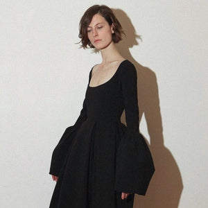 Architectural shapes and inherent femininity are two hallmarks of the A.W.A.K.E. Mode brand. Producing pieces that feel defined and structured yet still manage to be elegant and ethereal, the labeloffers a masterclass in modern dressing. This dress feels evidential of that, combining a figure-hugging top with a full skirt and vibrant, puffed sleeves.