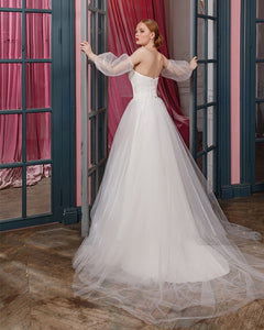 Be the belle of the ball (or wedding) in our stunning Robe Zari! This elegant and versatile gown features a removable puffy sleeve, side slit, and unique tulle design. Perfect for any special occasion, this dress won't disappoint. 