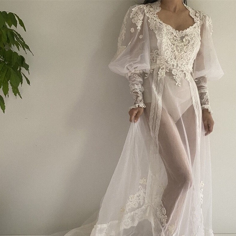 Wrap yourself in luxury and comfort with our Nightgown Addila. Made with delicate white lace and tailored to perfection, this robe-de-nuit will make you feel feminine and chic. With long sleeves and a gathered tulle design, it's the perfect addition to your bedtime routine. Treat yourself to a good night's sleep in style.