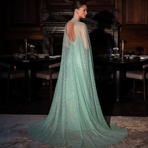 The Robe Juliene is an elegant and sophisticated evening gown, perfect for any special occasion. Its sparkling design and long cape add a touch of chic to your look. With this gown, you'll feel like the star of the night.