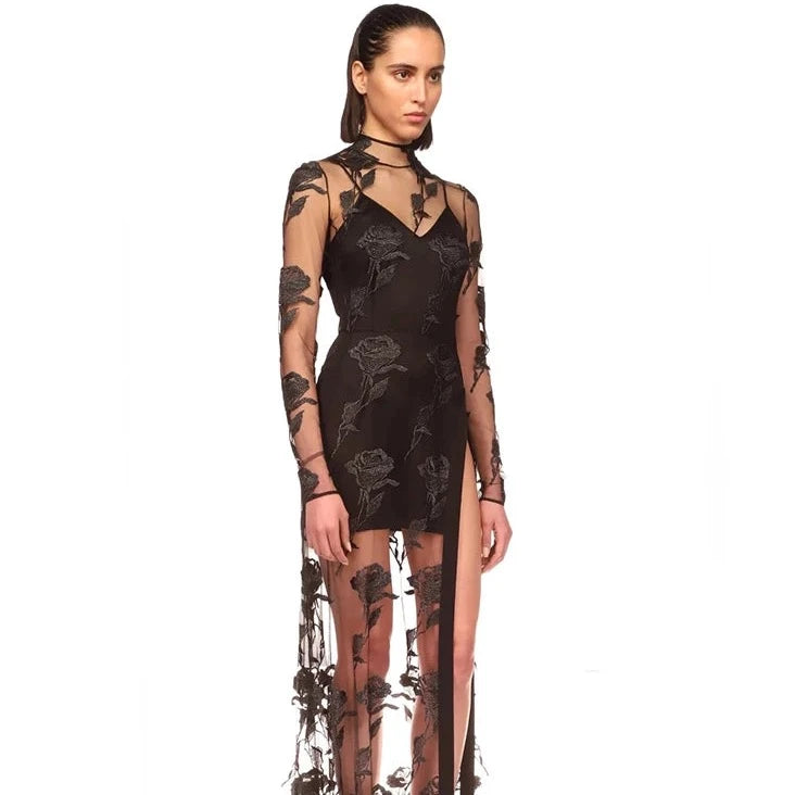 This Rose Macrame Slit Gown in Black is an elegantly designed dress that features long sleeves, a sexy lace design, and a split mesh detail. Designed to enhance your natural curves, this dress is perfect for any formal occasion. Its intricate macrame details and feminine silhouette will make you stand out in a crowd.