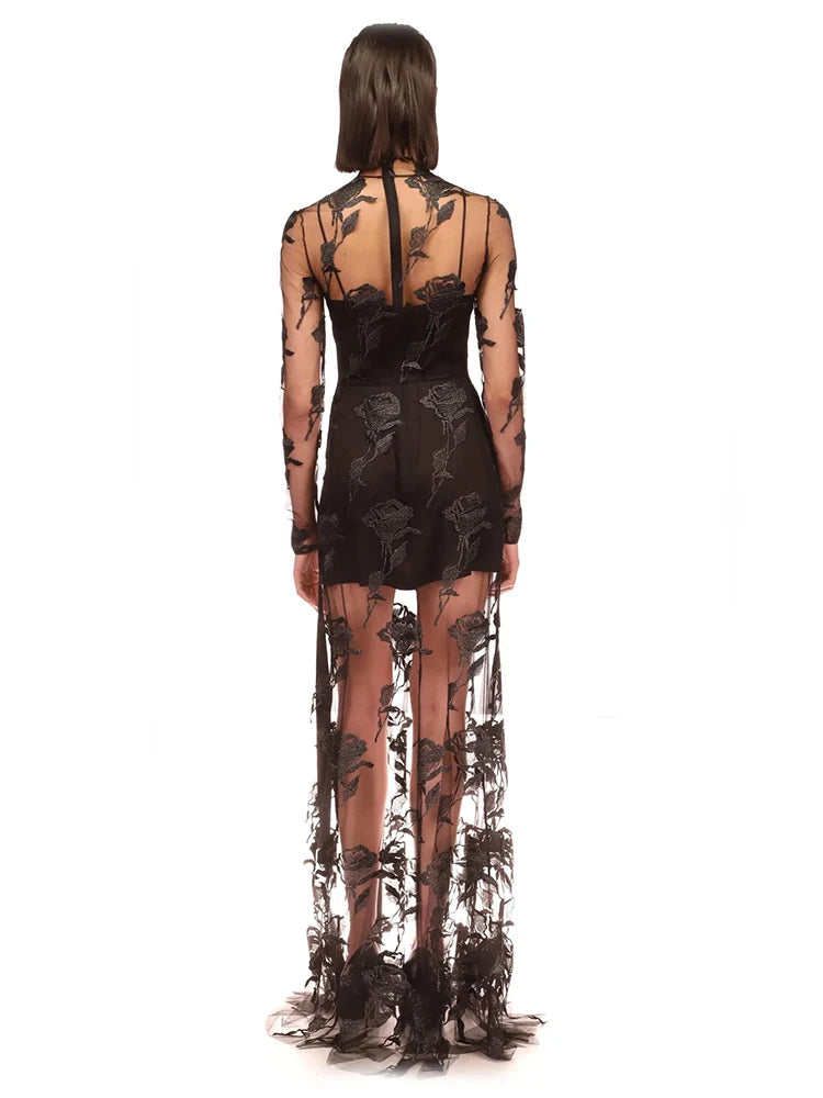 This Rose Macrame Slit Gown in Black is an elegantly designed dress that features long sleeves, a sexy lace design, and a split mesh detail. Designed to enhance your natural curves, this dress is perfect for any formal occasion. Its intricate macrame details and feminine silhouette will make you stand out in a crowd.