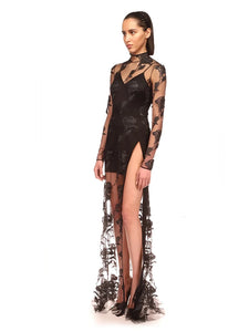 This Rose Macrame Slit Gown in Black is an elegantly designed dress that features long sleeves, a sexy lace design, and a split mesh detail. Designed to enhance your natural curves, this dress is perfect for any formal occasion. Its intricate macrame details and feminine silhouette will make you stand out in a crowd.