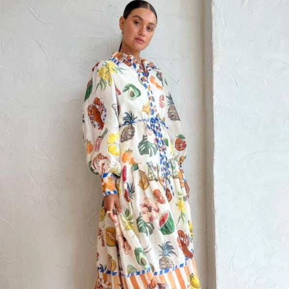 Indulge in luxury with our Robe Holle. This exquisite shirt dress boasts a vibrant still-life print of luscious fruits and majestic animals. The Theo graphic-print adds a touch of sophisticated elegance to your wardrobe. Be the center of attention with this one-of-a-kind piece.