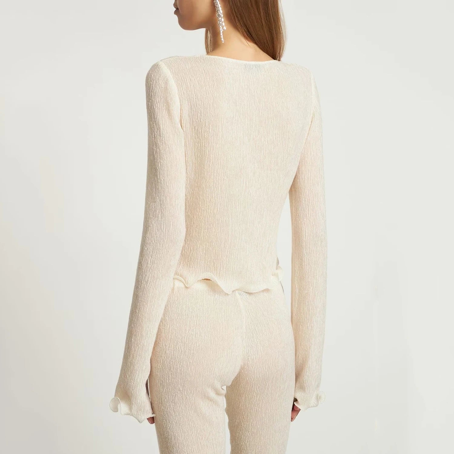 Elevate your wardrobe with the Ensemble Alice Shirred Knit Flower by Magda Butrym. Adorned with wooden ear trim and delicate three-dimensional flowers, this long-sleeved shirt and blouse set exudes a sense of sophistication and elegance. The lightweight, knitted fabric adds a touch of luxury to your everyday style.