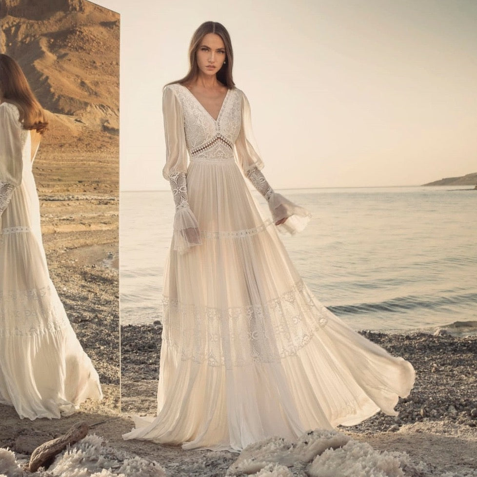 Introducing the Robe Rowane: a dreamy, elegant lace wedding gown that will make any bride feel like a boho princess. With delicate embroidery and long sleeves, this gown is both stylish and timeless. Perfect for a romantic and whimsical wedding, it will surely make all of your bridal dreams come true.