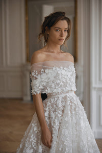 Look the part on your special day in the Robe Peggy, a beautiful bridal gown featuring thoughtfully crafted details that will take your look to the next level! From a timeless silhouette to intricate details, this gown is sure to make a statement. So turn heads and have the best wedding ever!