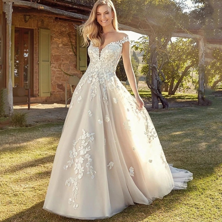 Be the center of attention with the elegant and stylish Robe Kerensa. This V-neck wedding dress is perfect for the fashion-forward bride, complete with cap sleeves and intricate lace appliques. Make a statement on your special day with the stunning Robe Kerensa.