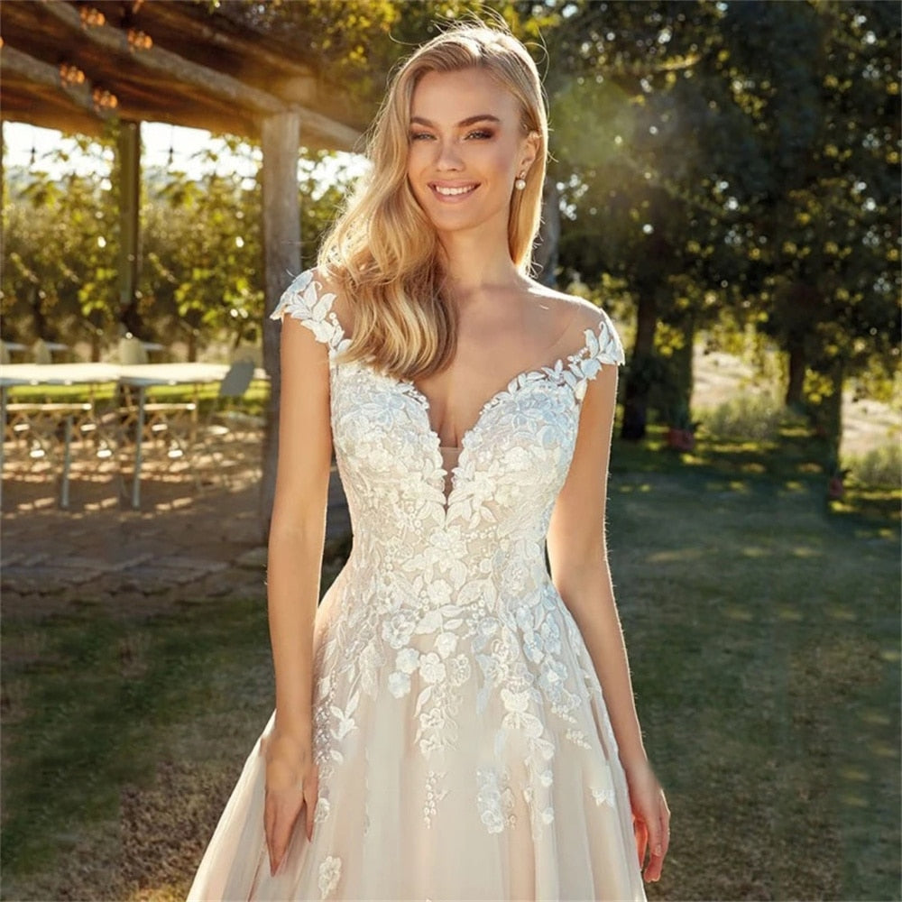 Be the center of attention with the elegant and stylish Robe Kerensa. This V-neck wedding dress is perfect for the fashion-forward bride, complete with cap sleeves and intricate lace appliques. Make a statement on your special day with the stunning Robe Kerensa.